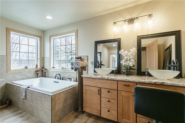 1965 Main St, Carlton, NY 14571 - full bath featuring tiled bath, wood finished floors, and double vanity