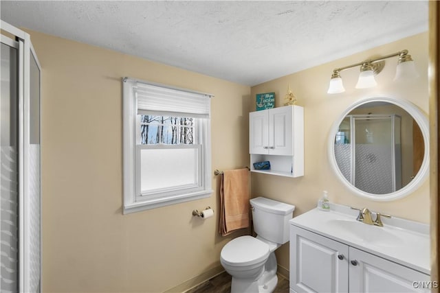 full bathroom with a stall shower, toilet, baseboards, vanity, and wood finished floors
