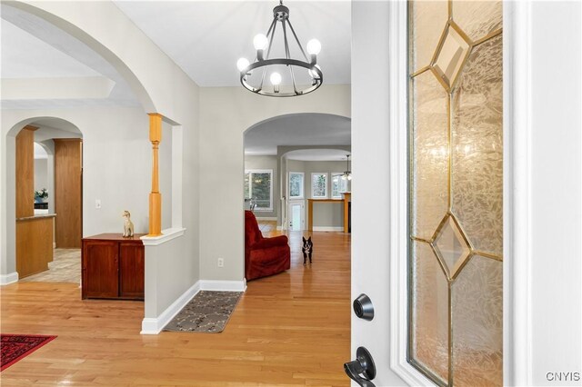 8312 Partridgeberry Dr, Lysander, NY 13027 - foyer entrance with wood finished floors, baseboards, a chandelier, and arched walkways