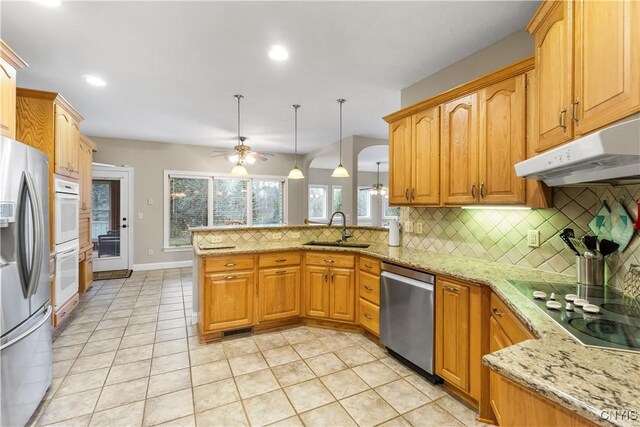 8312 Partridgeberry Dr, Lysander, NY 13027 - kitchen featuring appliances with stainless steel finishes, under cabinet range hood, a peninsula, tasteful backsplash, and a sink