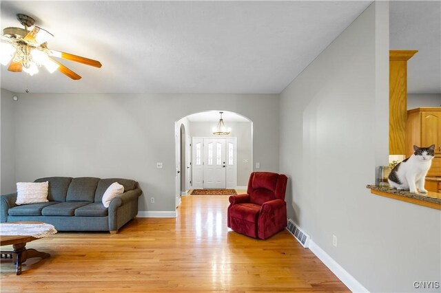 8312 Partridgeberry Dr, Lysander, NY 13027 - living room with arched walkways, light wood finished floors, ceiling fan, and baseboards