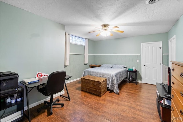 8312 Partridgeberry Dr, Lysander, NY 13027 - bedroom featuring wood finished floors, a textured ceiling, tile walls, an office area, and a ceiling fan