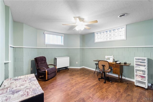 8312 Partridgeberry Dr, Lysander, NY 13027 - office featuring wood finished floors, a ceiling fan, a textured ceiling, concrete block wall, and wainscoting