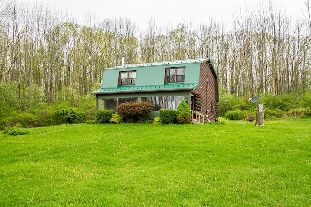 view of front of property with a gambrel roof, a front yard, and metal roof