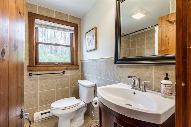 bathroom featuring a baseboard heating unit, tile walls, toilet, vanity, and tile patterned floors