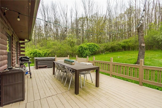 wooden terrace featuring outdoor dining space, a lawn, and area for grilling