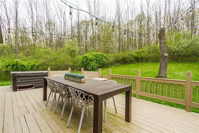 wooden terrace with outdoor dining area and a lawn