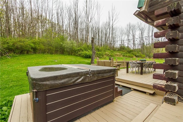 wooden deck with a hot tub, outdoor dining area, and a lawn
