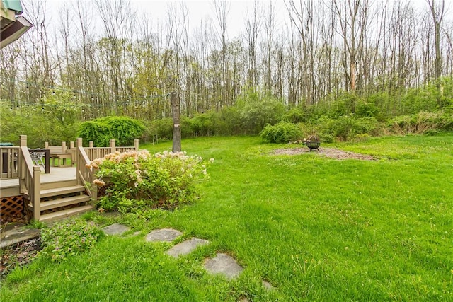 view of green lawn with a deck