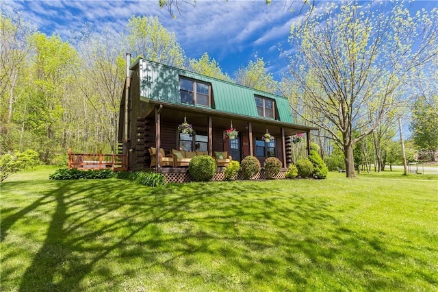 log home with metal roof, log siding, a front yard, and a porch