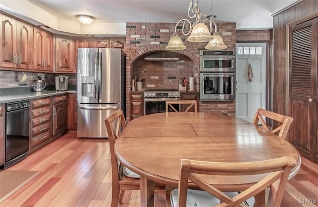 kitchen with stainless steel appliances, light wood-type flooring, backsplash, and brown cabinetry