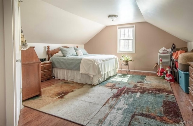 bedroom with wood finished floors and vaulted ceiling