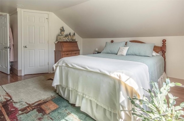 bedroom with vaulted ceiling and wood finished floors
