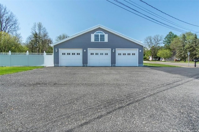 detached garage featuring fence