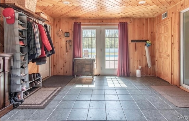 doorway with wooden ceiling and wood walls