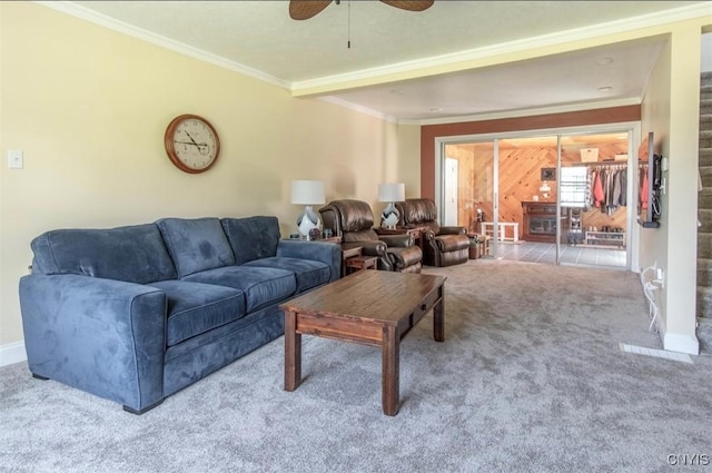 carpeted living room featuring ceiling fan, crown molding, and baseboards
