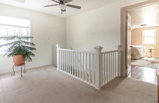 corridor featuring carpet flooring and an upstairs landing