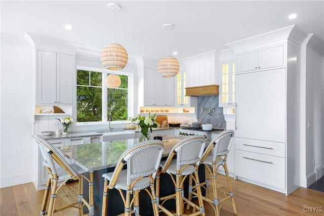 kitchen featuring white cabinets, decorative backsplash, glass insert cabinets, recessed lighting, and baseboards