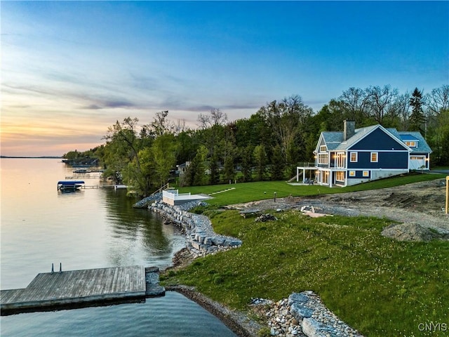 dock area with a water view and a lawn