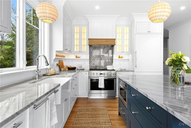 kitchen featuring stainless steel appliances, blue cabinets, white cabinetry, plenty of natural light, and recessed lighting
