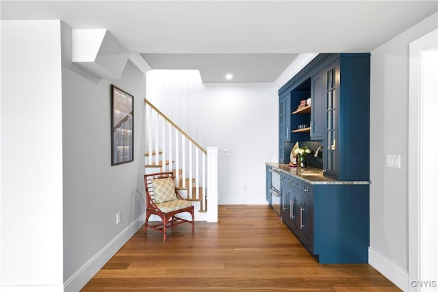 indoor bar with wood finished floors, stairs, baseboards, and recessed lighting