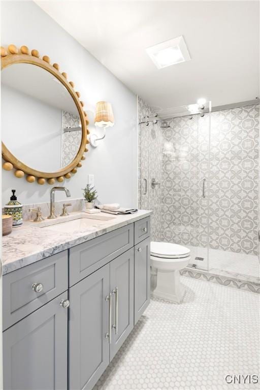 bathroom featuring toilet, vanity, and a stall shower