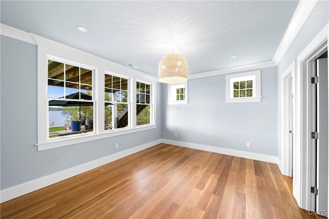 empty room featuring baseboards, light wood-style floors, recessed lighting, and crown molding