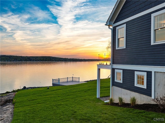 dock area featuring a water view and a lawn