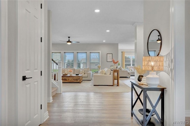 living room with stairway, ceiling fan, light wood finished floors, recessed lighting, and baseboards