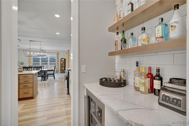 indoor dry bar with light wood finished floors, wine cooler, recessed lighting, tasteful backsplash, and gas range