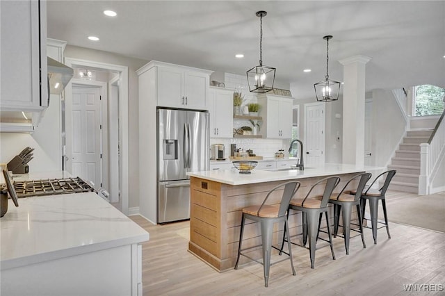 kitchen with stainless steel fridge, tasteful backsplash, open shelves, light wood finished floors, and recessed lighting