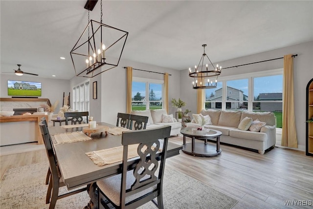 dining space featuring light wood-style flooring, a chandelier, a ceiling fan, and recessed lighting