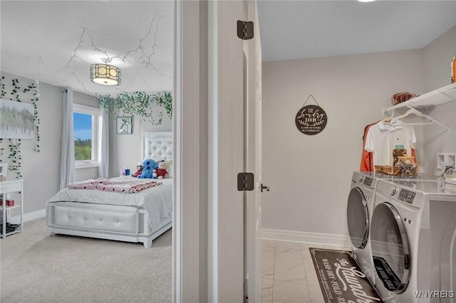 washroom featuring washing machine and dryer, baseboards, and light marble finish flooring