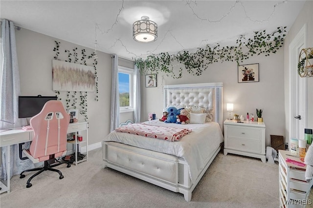 bedroom with light colored carpet and an office area