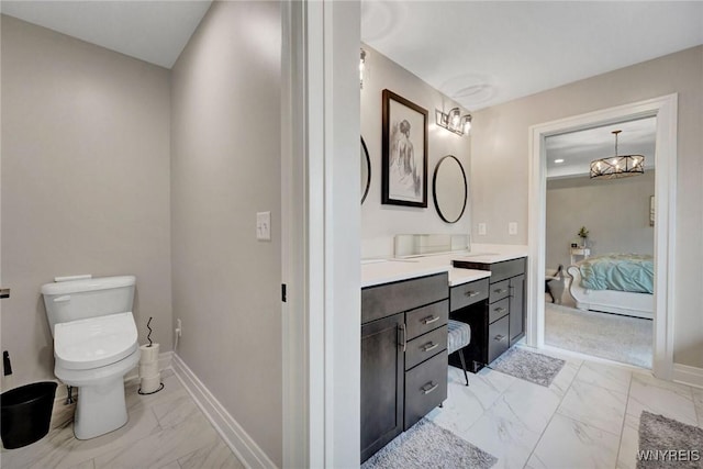 bathroom featuring marble look tile flooring, connected bathroom, toilet, vanity, and baseboards