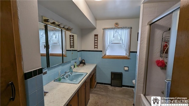 3738 E Lake Rd, Dunkirk-Town, NY 14048 - bathroom featuring a shower with shower door, vanity, toilet, a wainscoted wall, and tile walls