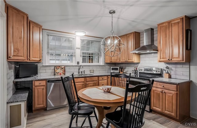 2810 Genesee St, Utica, NY 13502 - kitchen featuring wall chimney exhaust hood, stainless steel appliances, light wood finished floors, and a sink