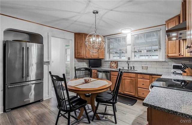 2810 Genesee St, Utica, NY 13502 - kitchen with stainless steel appliances, a chandelier, tasteful backsplash, and exhaust hood
