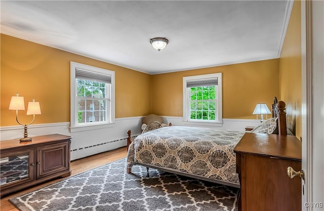 2810 Genesee St, Utica, NY 13502 - bedroom featuring wainscoting, baseboard heating, and wood finished floors