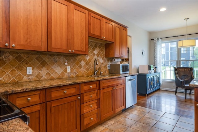 318 Wexford Ln, Horseheads, NY 14845 - kitchen with appliances with stainless steel finishes, brown cabinets, a sink, stone counters, and recessed lighting