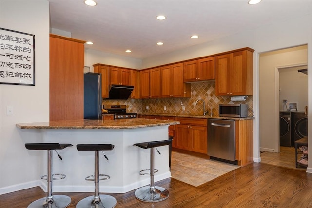 318 Wexford Ln, Horseheads, NY 14845 - kitchen with stainless steel appliances, independent washer and dryer, recessed lighting, dark stone counters, and a breakfast bar