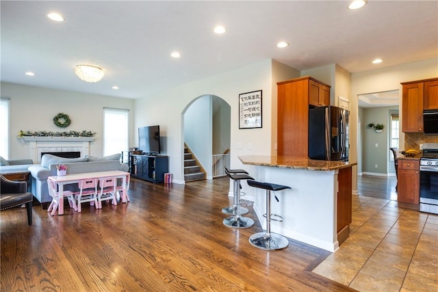 318 Wexford Ln, Horseheads, NY 14845 - kitchen with appliances with stainless steel finishes, open floor plan, a breakfast bar, a fireplace, and recessed lighting