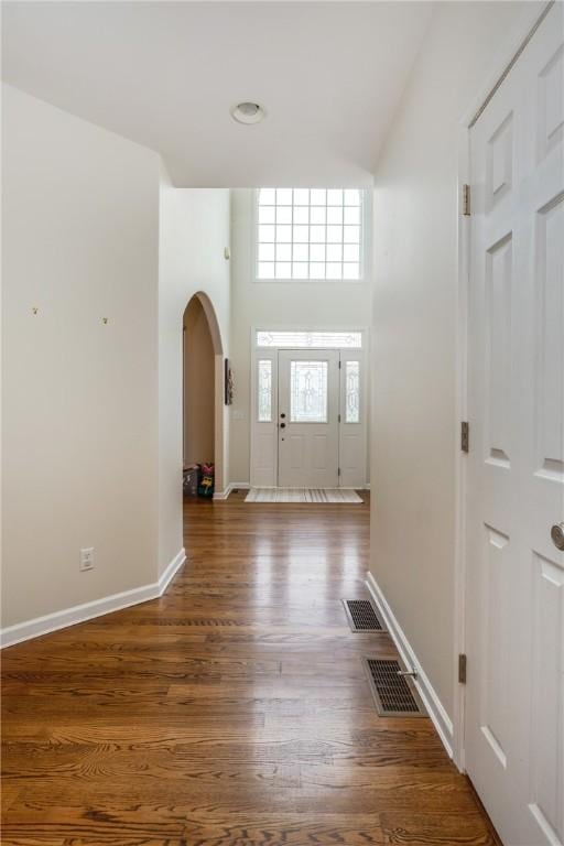 318 Wexford Ln, Horseheads, NY 14845 - foyer entrance featuring arched walkways, a towering ceiling, baseboards, and wood finished floors