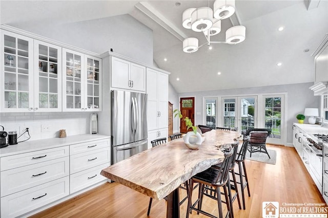 3 Maple Ave, Chautauqua, NY 14722 - kitchen featuring stainless steel fridge, white cabinets, glass insert cabinets, light countertops, and light wood-style floors