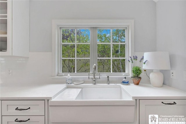 3 Maple Ave, Chautauqua, NY 14722 - kitchen with a sink, backsplash, white cabinetry, light countertops, and glass insert cabinets