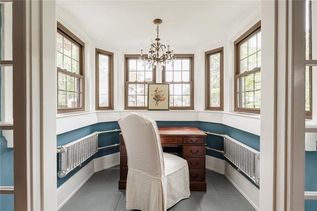 tiled office with plenty of natural light, a chandelier, radiator, and baseboards