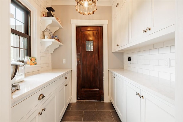 interior space featuring a chandelier and dark tile patterned flooring