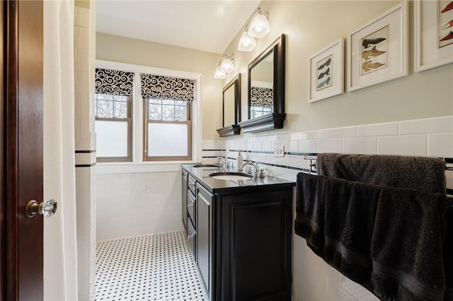 bathroom with tile walls, a wainscoted wall, and double vanity
