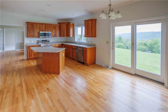 490 Hidden Falls Rd, Tully, NY 13159 - kitchen with stainless steel appliances, a sink, crown molding, a chandelier, and brown cabinetry