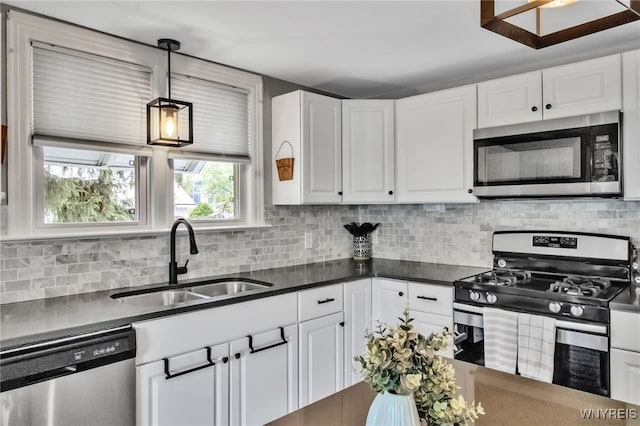 5031 Armor Duells Rd, Orchard Park, NY 14127 - kitchen featuring stainless steel appliances, a sink, dark countertops, white cabinetry, and backsplash